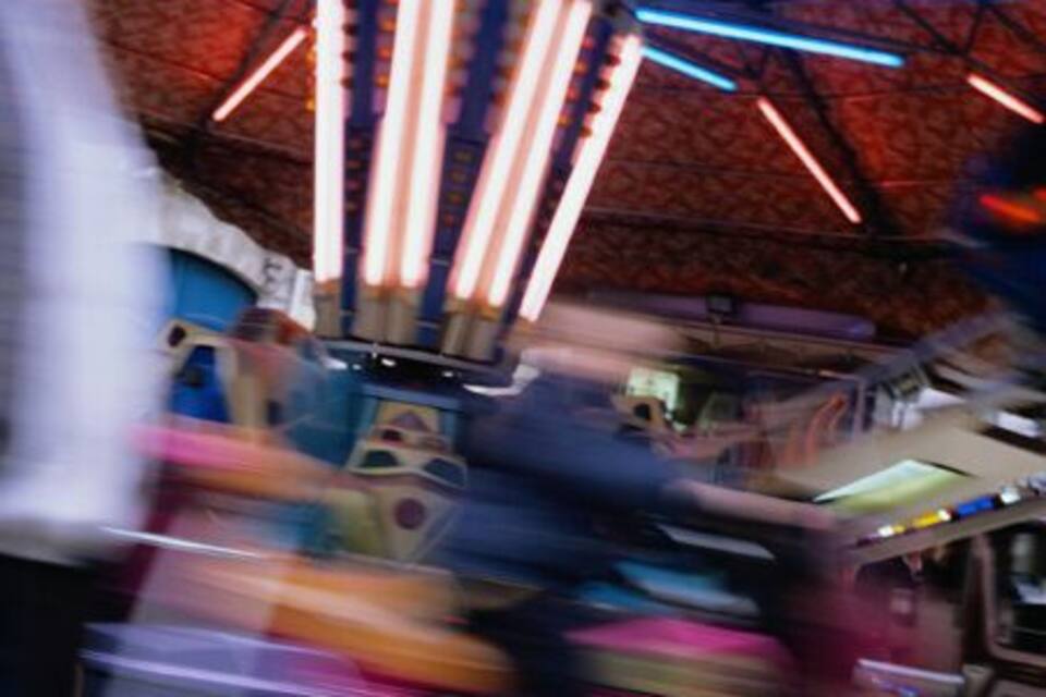 A carousel with colorful lights and a blurred background.