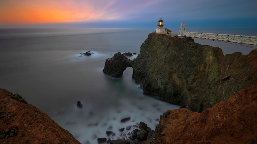 A view westward of Point Bonita Light House in the Marin Headlands of Northern California near San Francisco, after the sun has set with the blur of the ocean crashing on the waves below