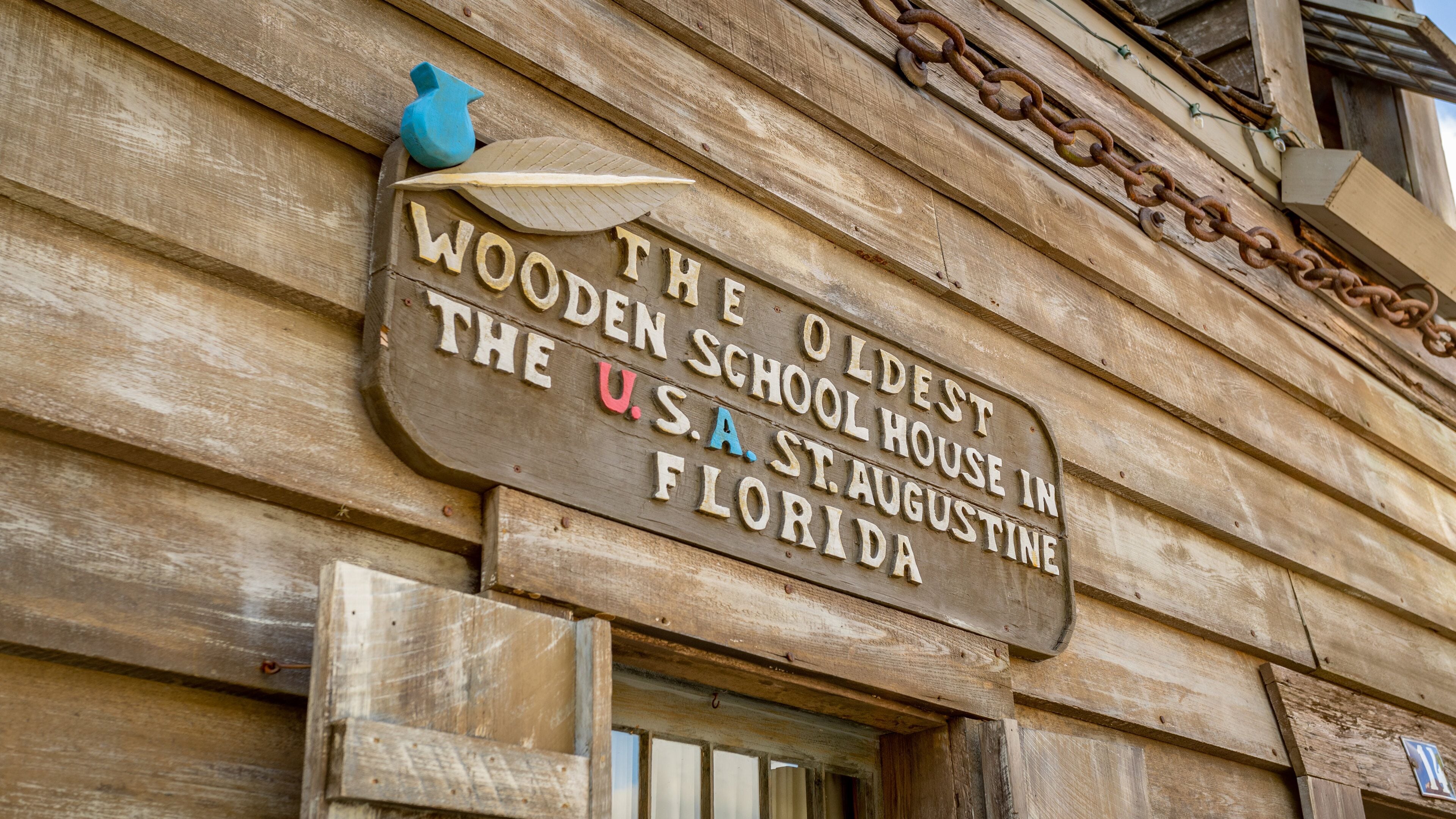 Oldest Wooden School House which includes signage