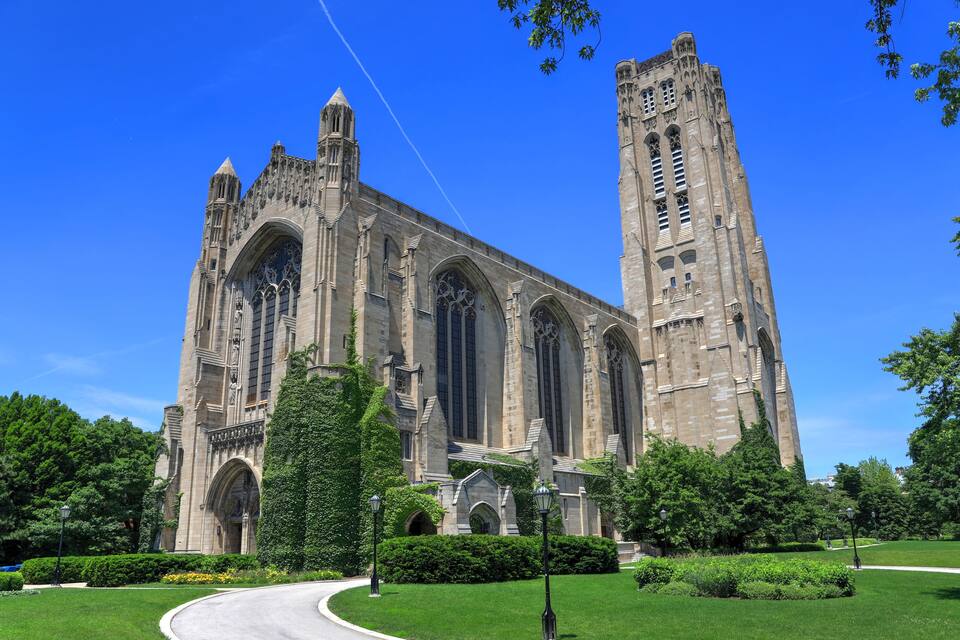A large Gothic-style cathedral with twin towers and a well-maintained garden in front.