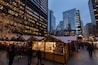 A bustling urban market with wooden stalls and Christmas decorations.