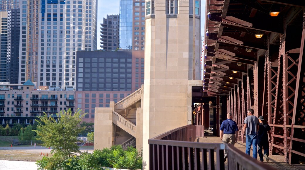 Chicago Riverwalk showing a bridge and a city as well as a small group of people