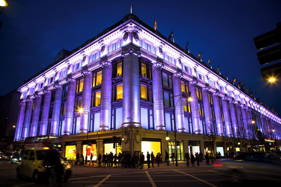 A large, illuminated building with classical architecture at night.