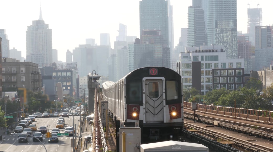 A train on tracks with a city skyline in the background.