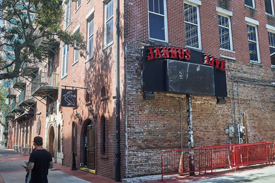 Un edificio in mattoni con un cartello che recita 'JANNUS LIVE PUB'.