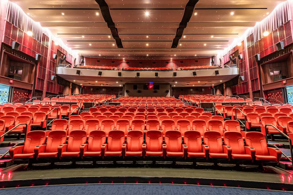 A large, empty theater with red seats and a modern design.