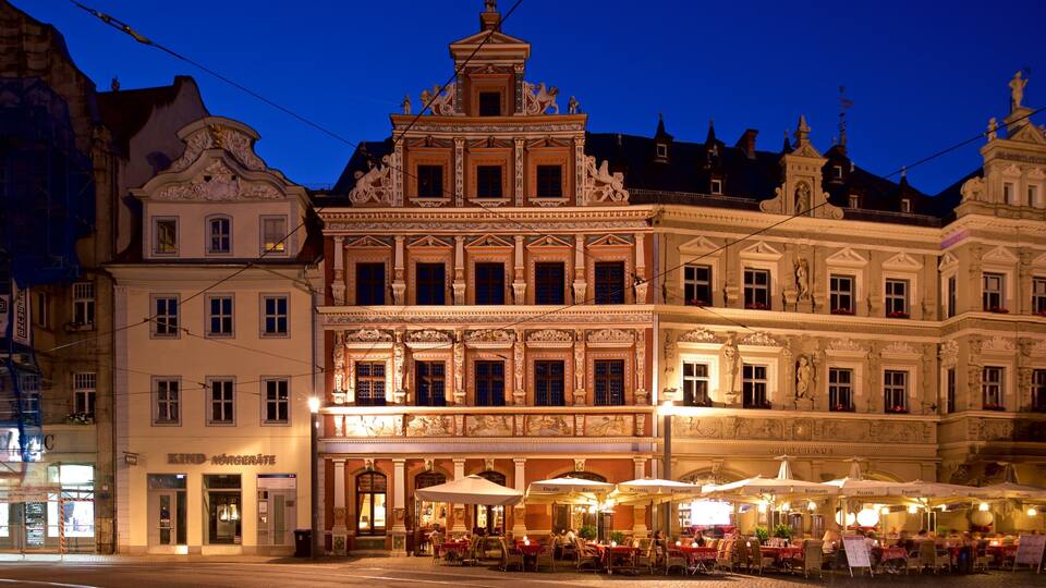 Ein historisches Gebäude mit aufwendiger Architektur und Außenbereich bei Nacht.