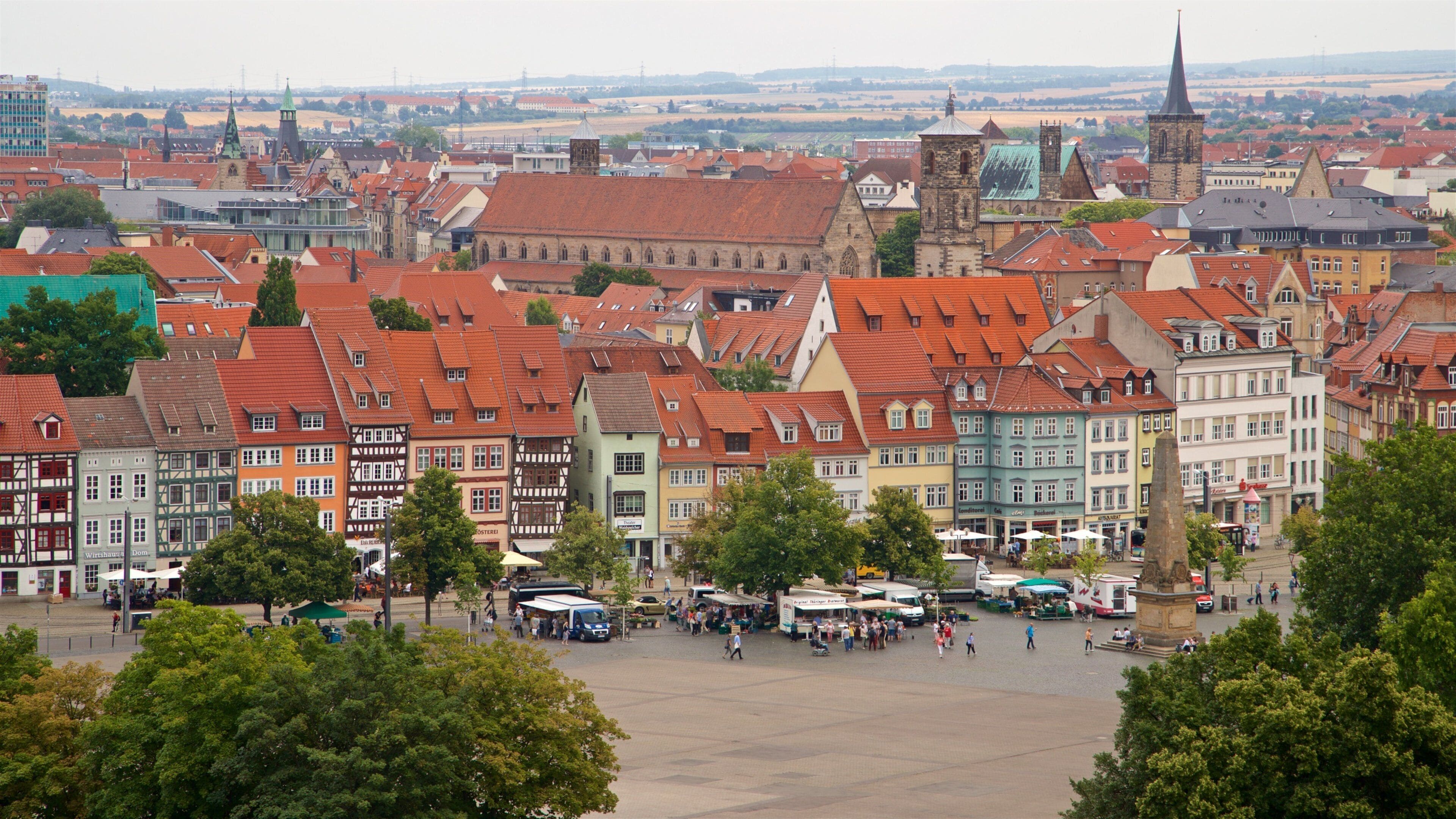 A historic town square with traditional half-timbered buildings and a prominent church tower.