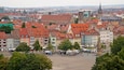 A historic town square with traditional half-timbered buildings and a prominent church tower.