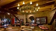 An interior with a wooden ceiling, stone walls, and a chandelier.