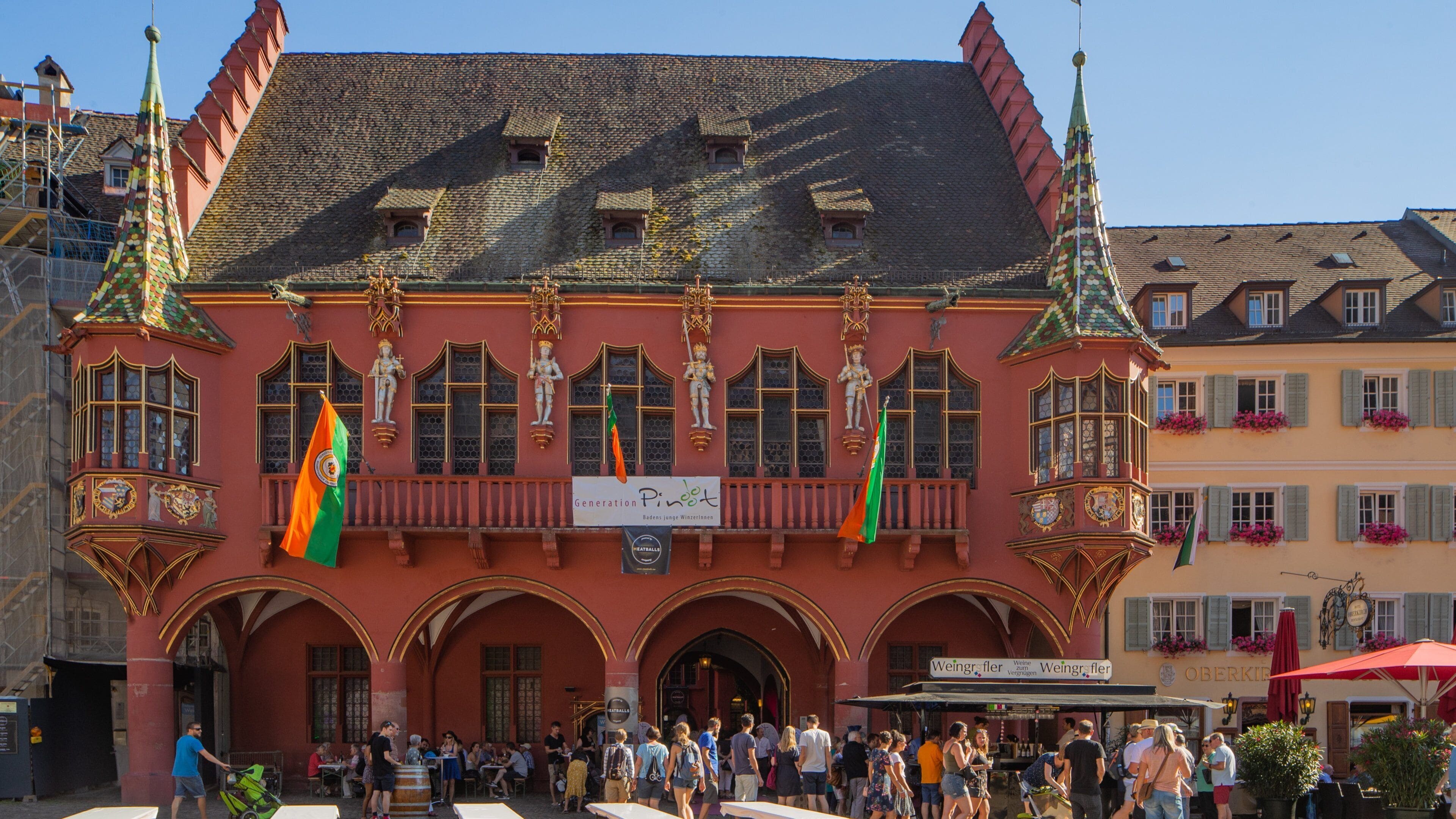 Historical Merchants\' Hall featuring heritage elements and outdoor eating as well as a large group of people