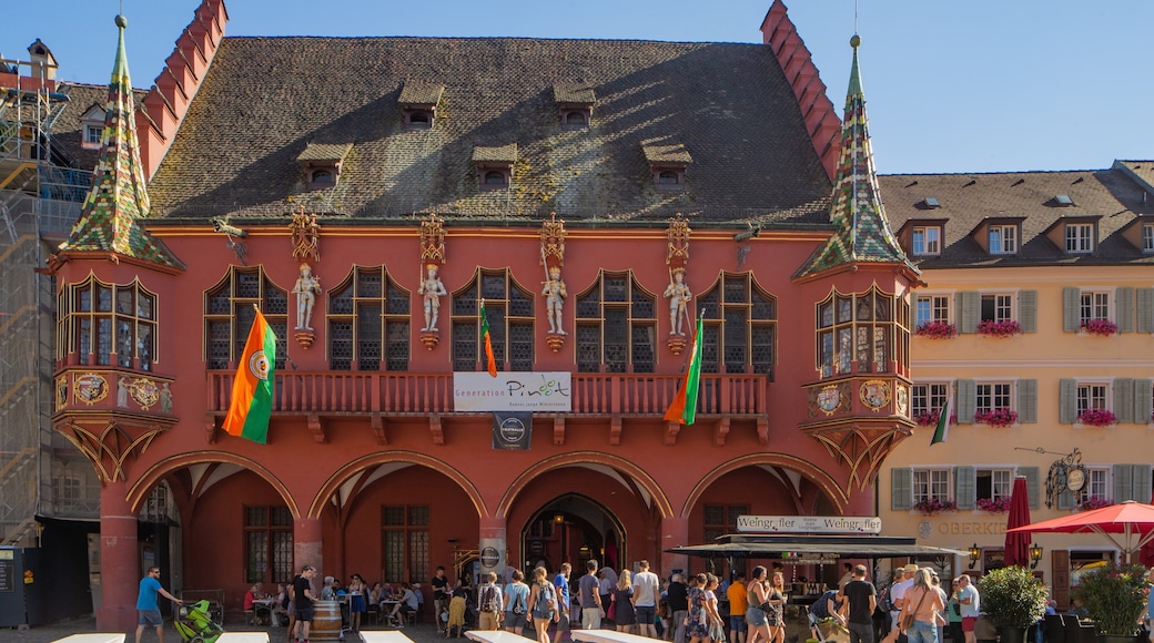 Historical Merchants\' Hall featuring heritage elements and outdoor eating as well as a large group of people