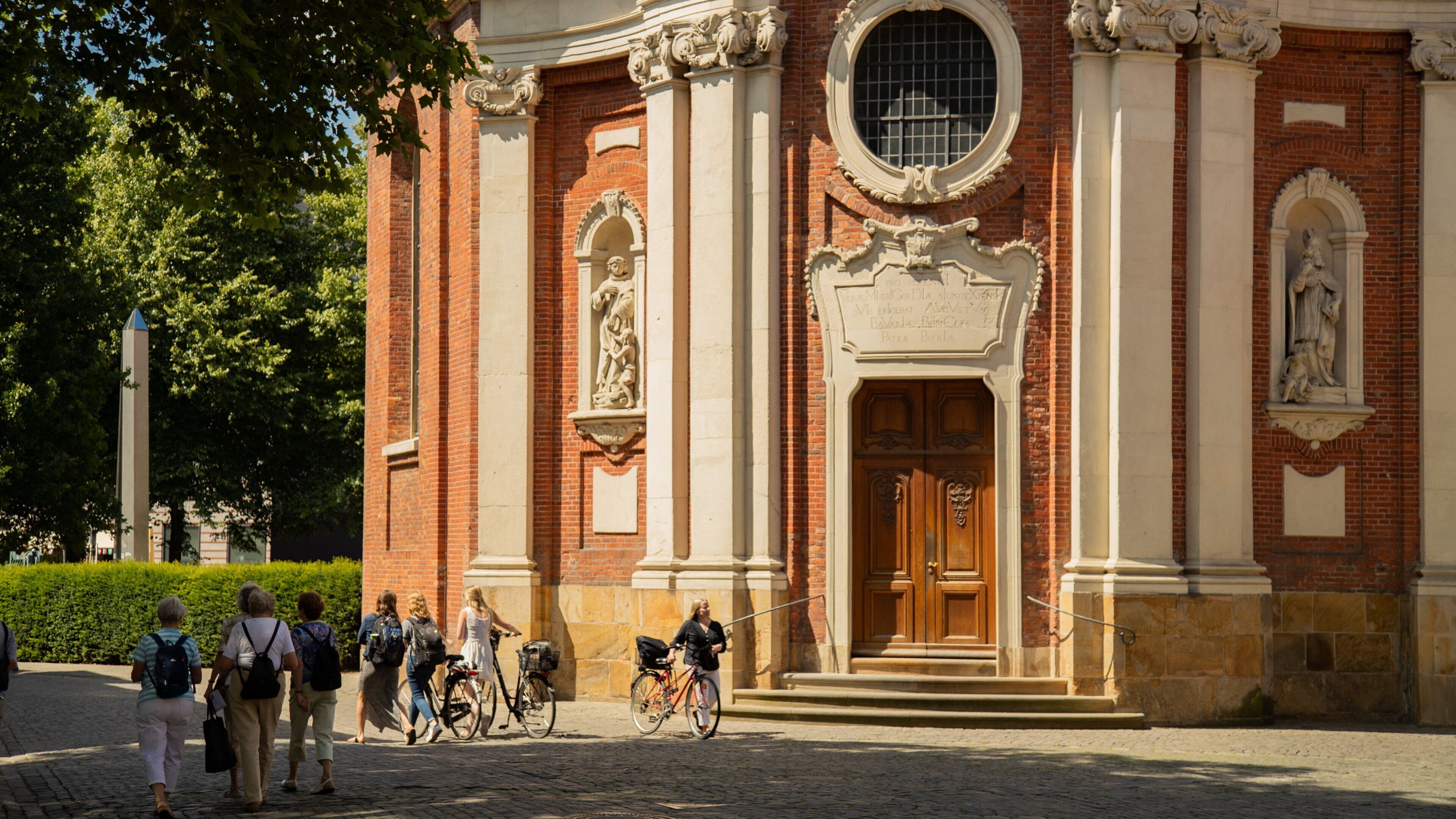 Clemenskirche featuring street scenes and heritage elements as well as a small group of people