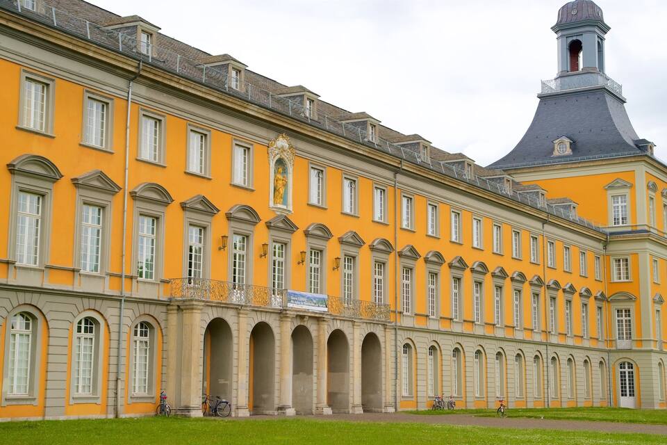 Un gran edificio amarillo con ventanas arqueadas y una torre.