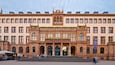 Suuri, historiallinen rakennus, jossa on useita ikkunoita ja keskeinen sisäänkäynti.
