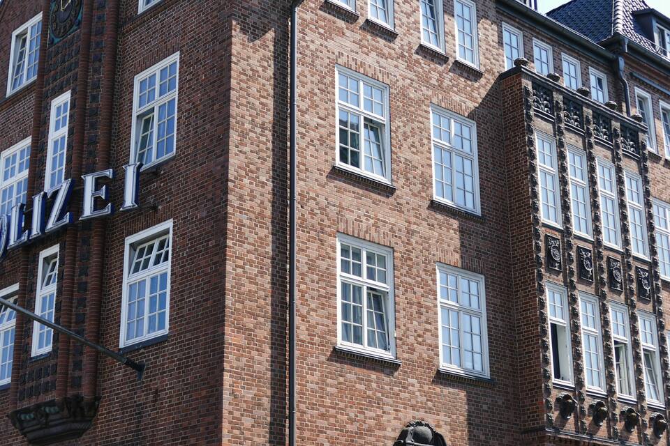 A red brick building with multiple windows and a sign that reads "POLIZEI".