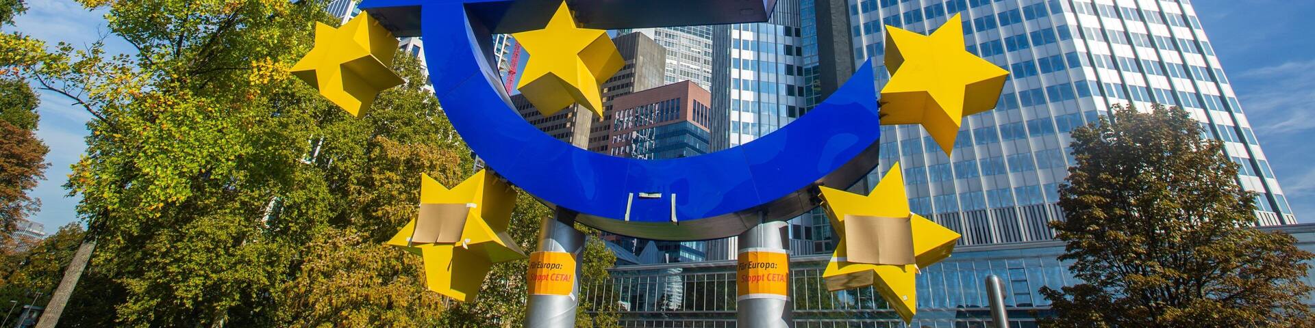 Euro Symbol which includes signage, a city and outdoor art