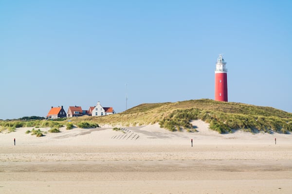 Beach, dunes and lighthouse of De Cocksdorp on West Frisian Waddensea island Texel, Netherlands; Shutterstock ID 612215561