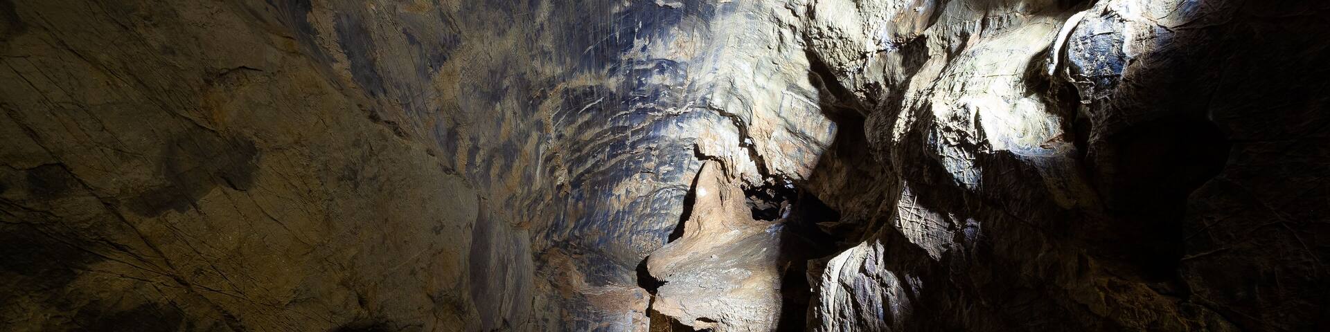 A narrow, dimly lit cave with a metal staircase leading upwards.