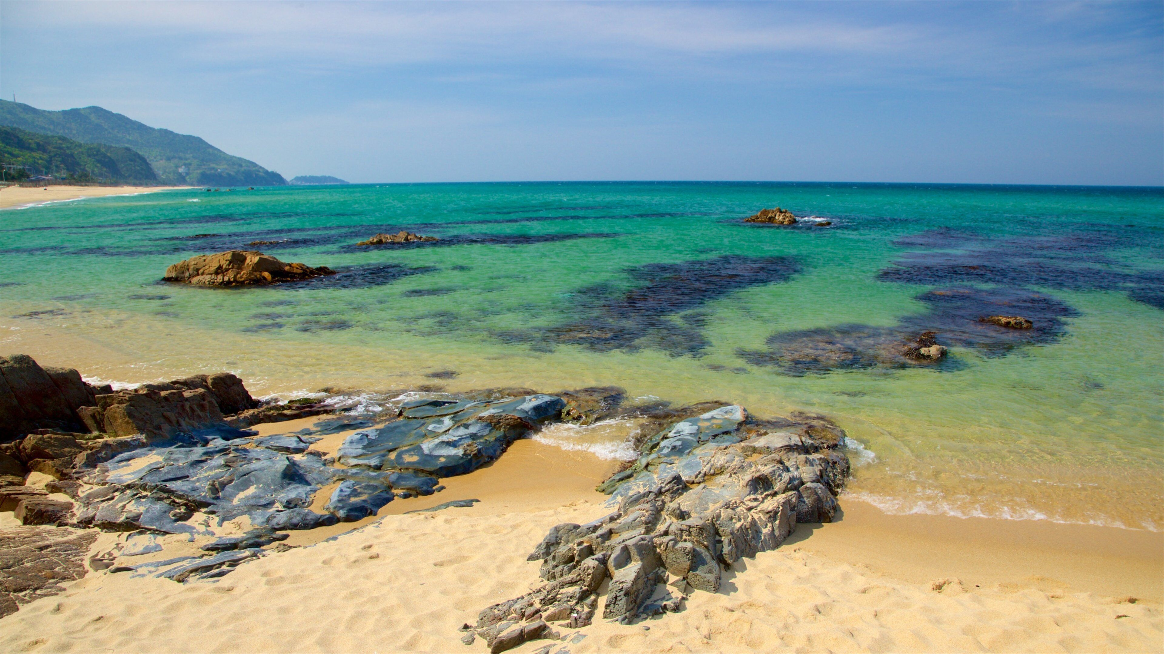 Jeongdongjin Beach which includes a beach, rocky coastline and general coastal views