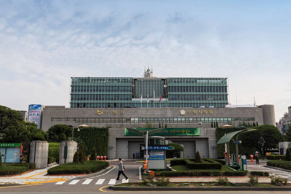 Un bâtiment moderne doté d’une grande entrée et d’un passage piéton devant.