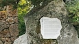 Een stenen monument met een plaquette met een historische inscriptie.