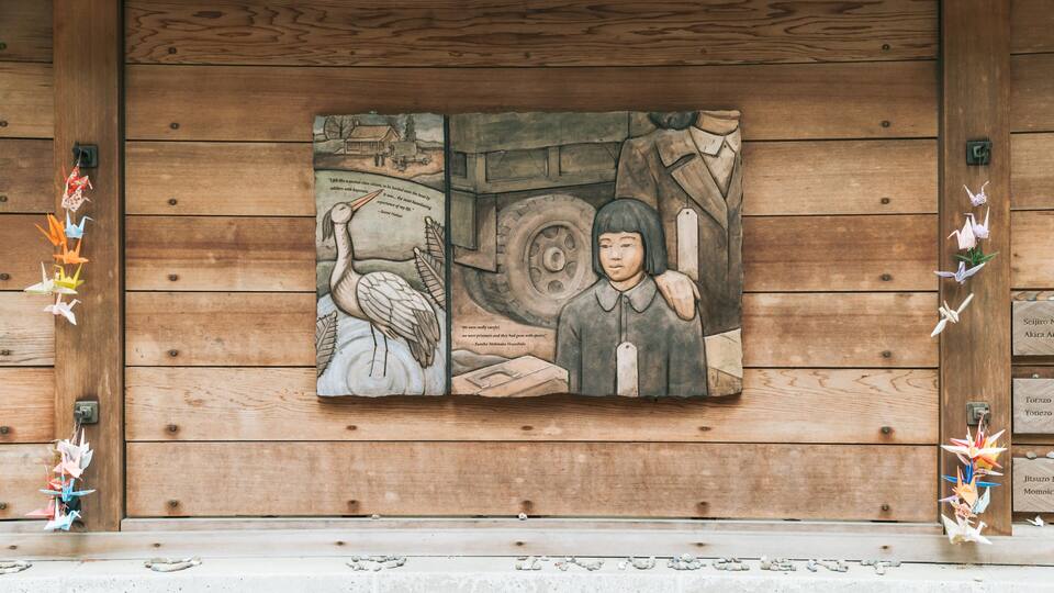A wooden wall with a mural depicting a scene with a crane and a person.