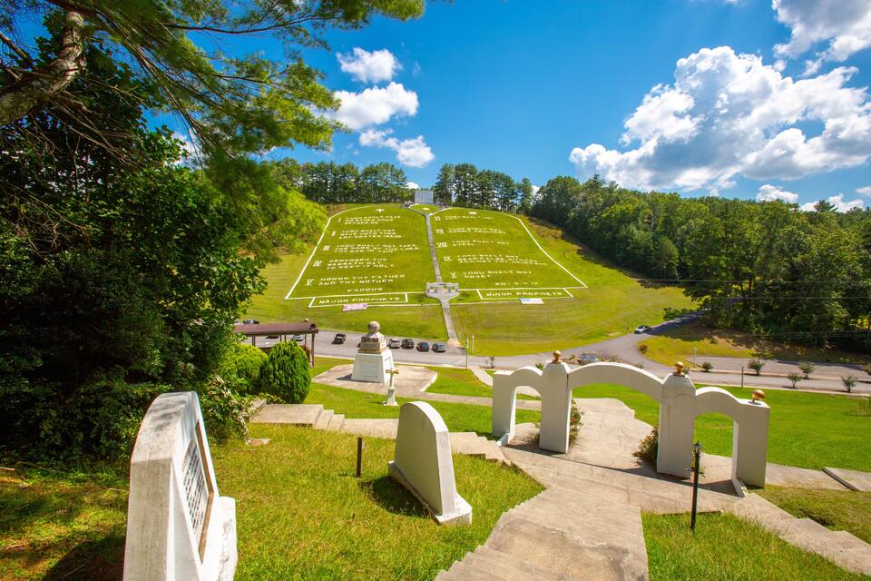 A cemetery with headstones arranged in rows and a crossroad in the background.