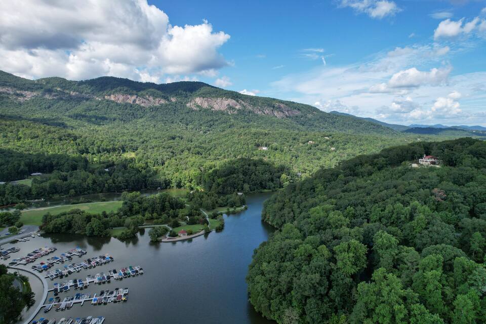 A lake surrounded by dense forest and mountains.