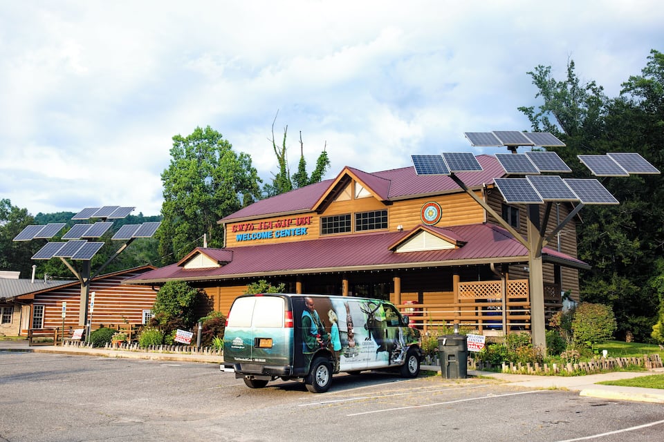A wooden building with a red roof and solar panels.