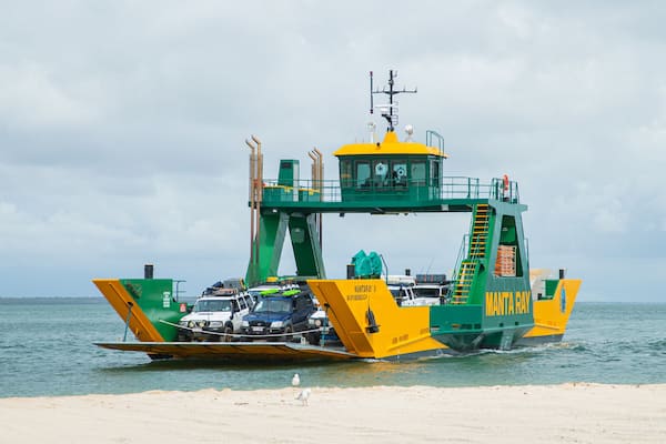 Eine grüne und gelbe Fähre namens Manta Ray II an einem Anleger.