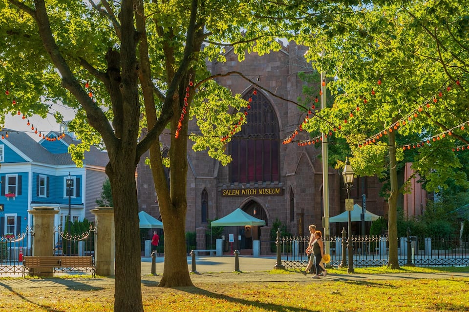 A Salem Witch Museum with a Gothic arch, surrounded by trees and street lamps.