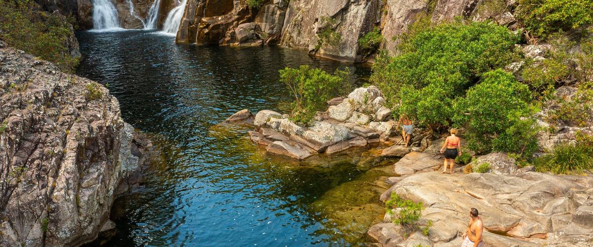 Behana Gorge featuring a river or creek and a cascade as well as a small group of people