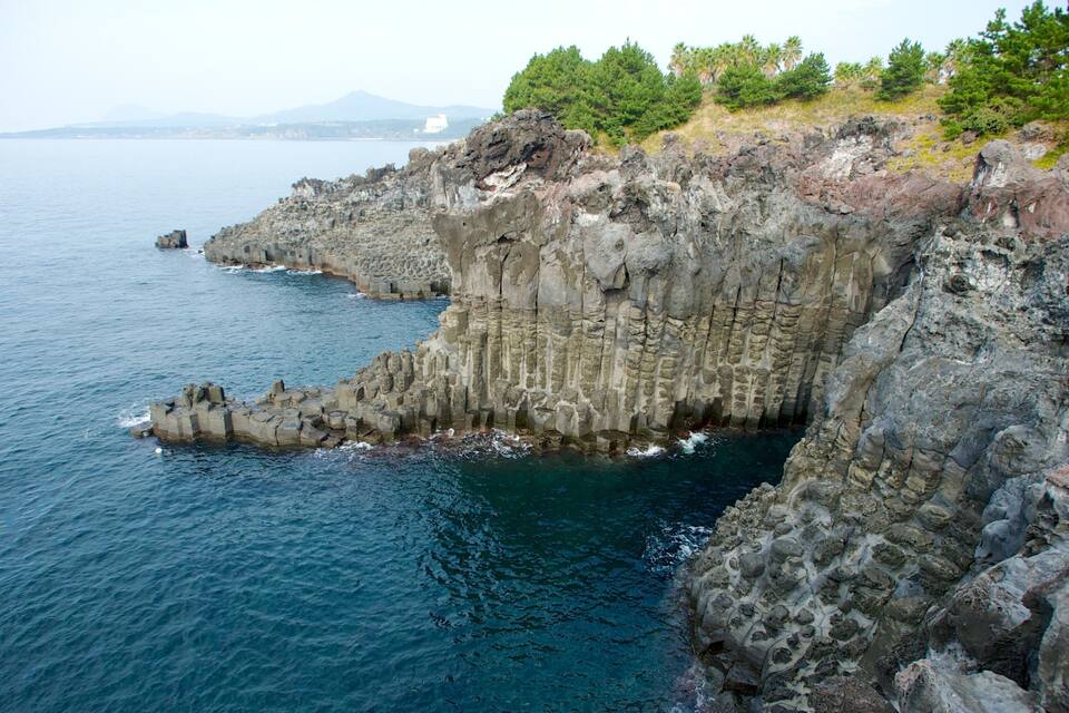 A rocky coastline with steep cliffs and a clear blue sea.