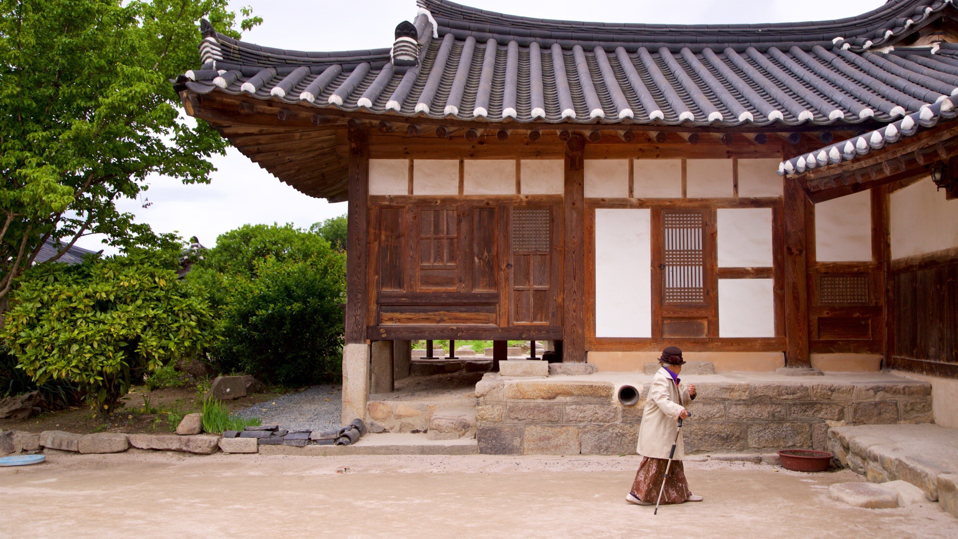 Gyeongju Gyochon Traditional Village showing heritage elements as well as an individual femail
