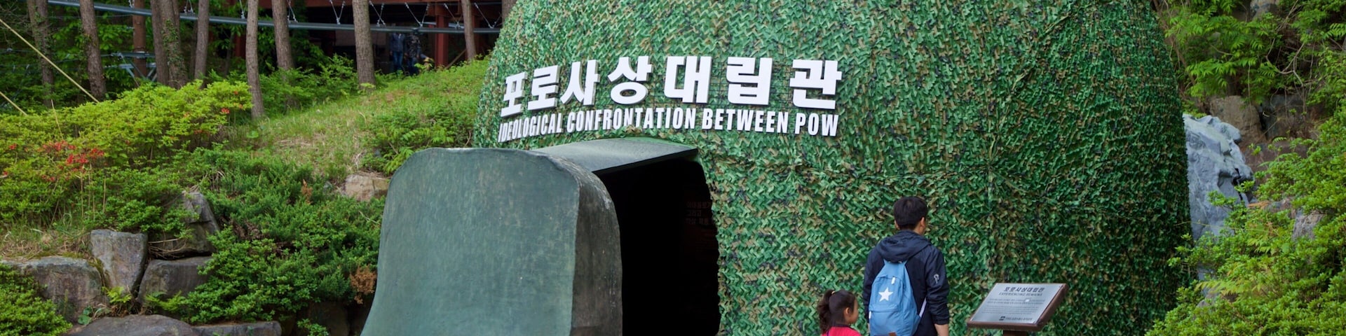 Geoje POW Camp showing a garden and signage as well as a family