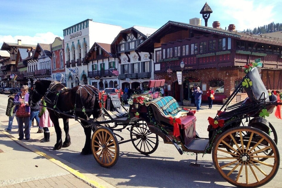 Eine Kutsche auf dem historischen Marktplatz mit traditioneller Bebauung.