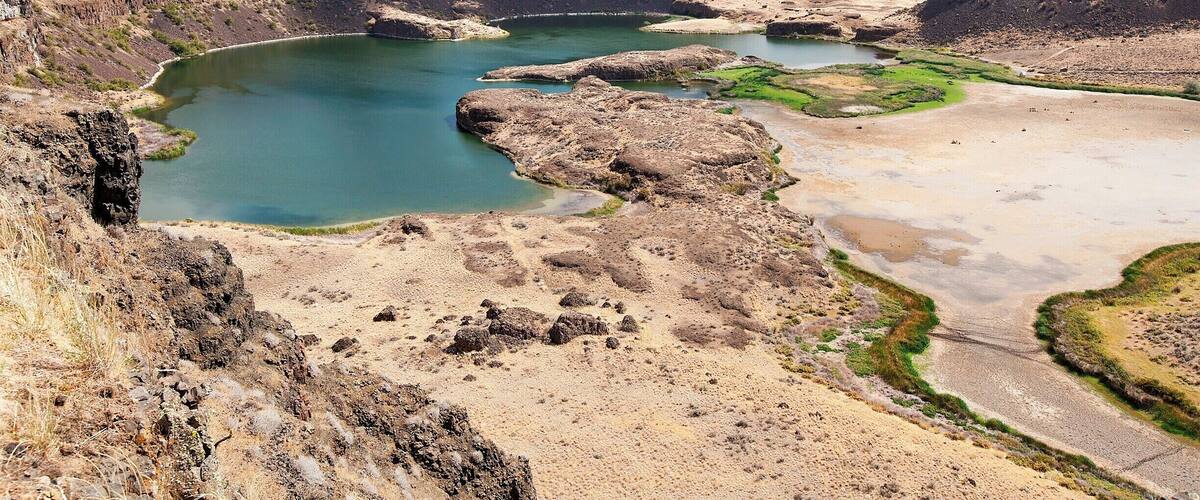 The greatest waterfall the world has ever seen?  That's what geologists tell us happened 20,000 years ago when a large glacial lake in Montana broke through it's 2000 foot tall (641 m) ice dam and flooded eastern Washington and Idaho with 600 cubic miles of water (2,500 cubic km).  The flood water rushed over this 400ft tall (121 m) ridge at 65mph (104 kmh), generating a flow roughly 10 times larger than the flow of all the world's rivers combined!  This happened roughly 40 times over a 2000-year period.
Today, Dry Falls is a state park with hiking trails, water sports and campgrounds.  Stop by the visitor's center for more info.