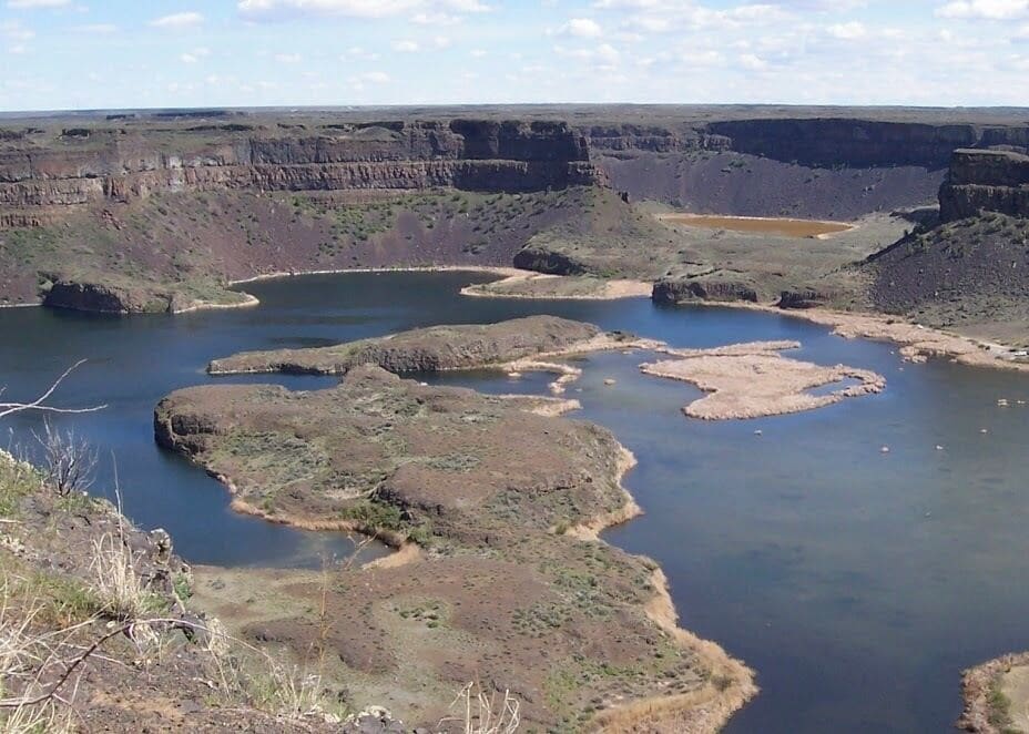 Washington Dry Falls is a 3.5-mile-long (5,600 m) scalloped precipice in central Washington, on the opposite side of the Upper Grand Coulee from the Columbia River, and at the head of the Lower Grand Coulee. According to the current geological model, catastrophic flooding channeled water at 65 miles per hour through the Upper Grand Coulee and over this 400-foot (120 m) rock face at the end of the last ice age. It is estimated that the falls were five times the width of Niagara,:116 with ten times the flow of all the current rivers in the world combined.
#Nature