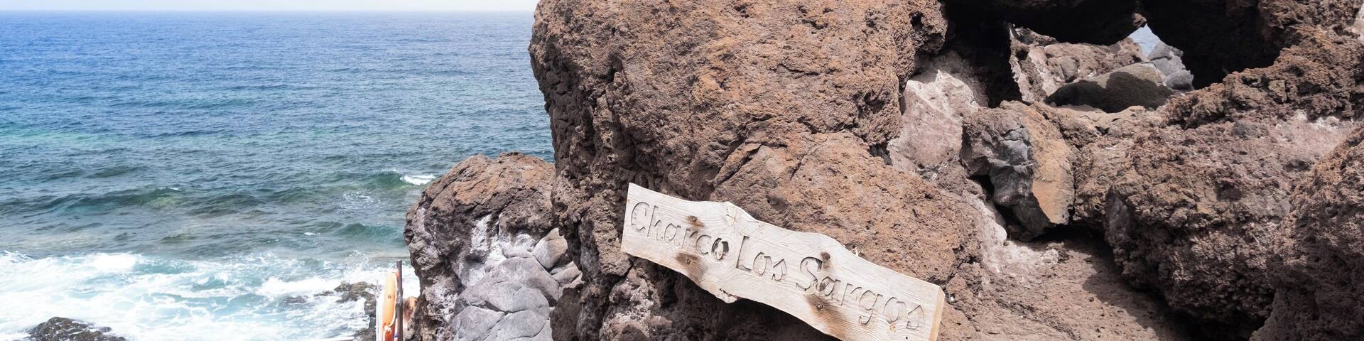 Costa rocosa con un letrero que dice 'Chorro Los Sargazos'.