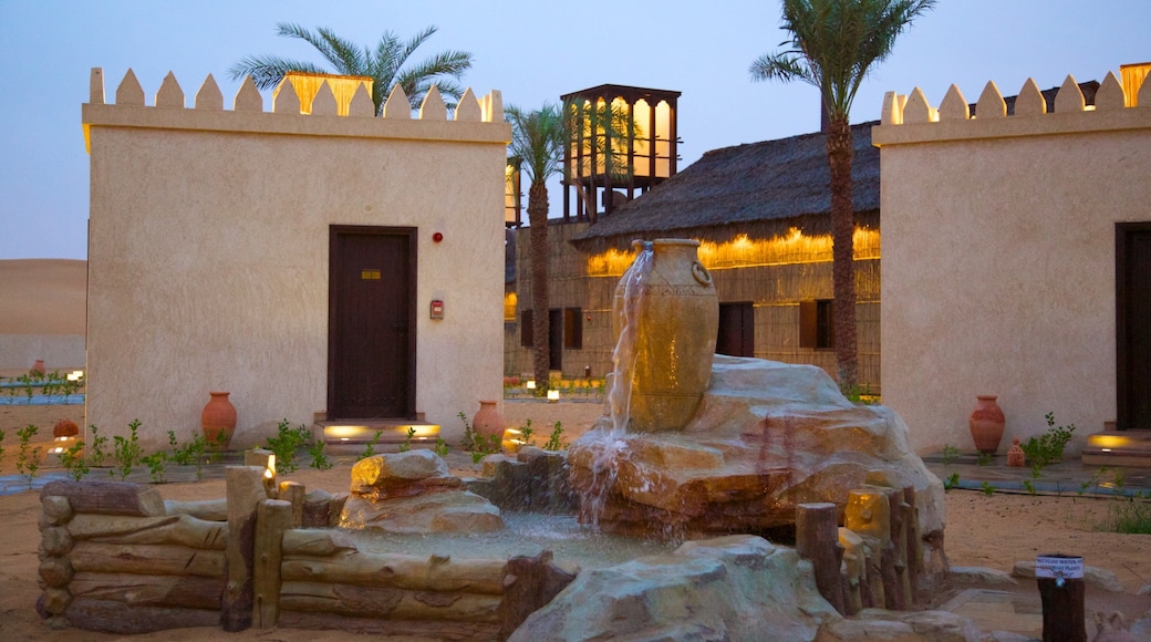 Emirato de Abu Dabi que incluye escenas nocturnas, una fuente y una pequeña ciudad o pueblo