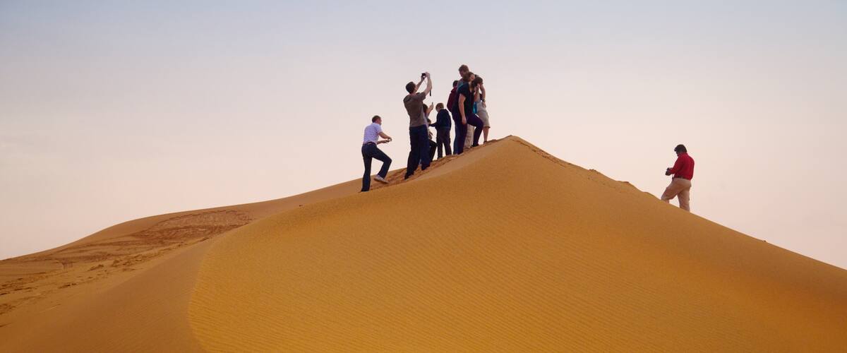 Abu Dhabi Emirate which includes hiking or walking and desert views as well as a small group of people