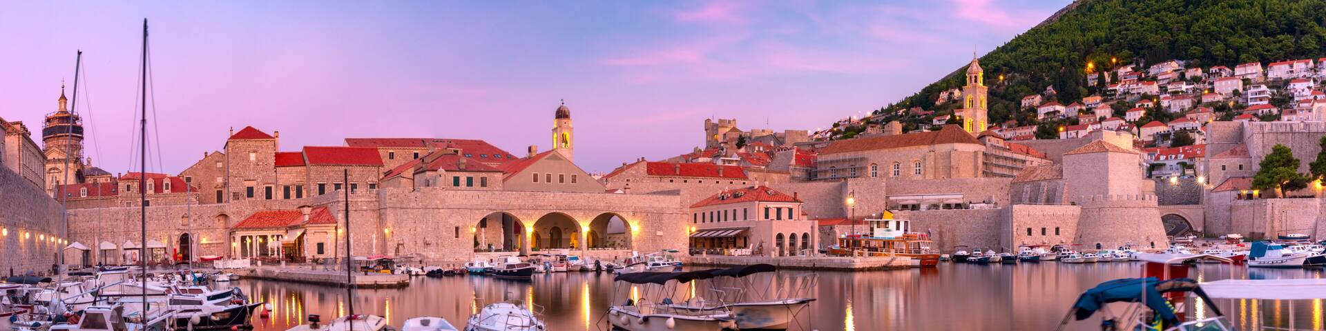 Panoramic view of Old Harbour with boats and Old Town of Dubrovnik at sunset, Croatia