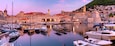 Panoramic view of Old Harbour with boats and Old Town of Dubrovnik at sunset, Croatia