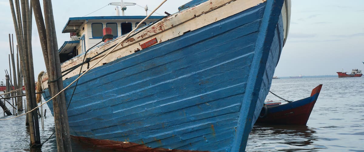 Fishing boat rests on fishing beach in dumai town