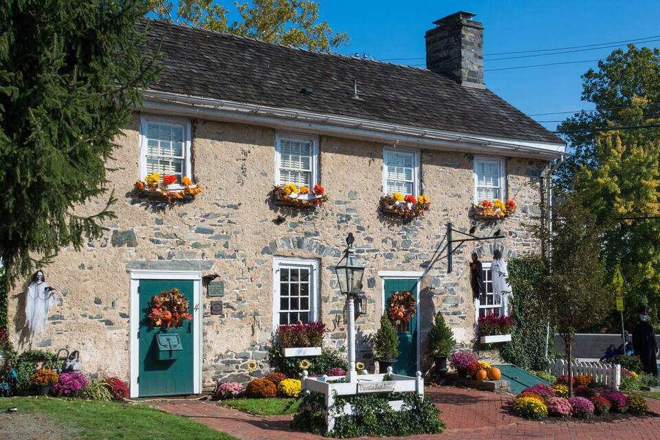 A stone building with flower boxes and a green door.