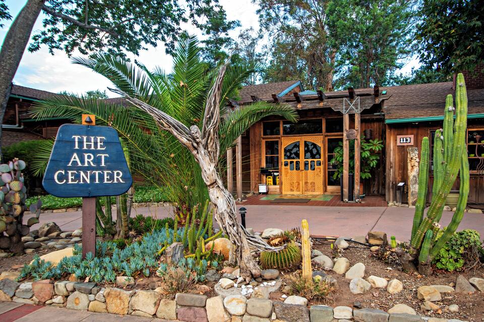 A wooden building with a sign that reads "The Art Center."