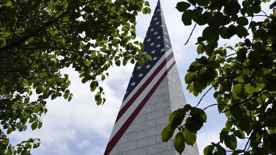 A tall monument with an American flag.