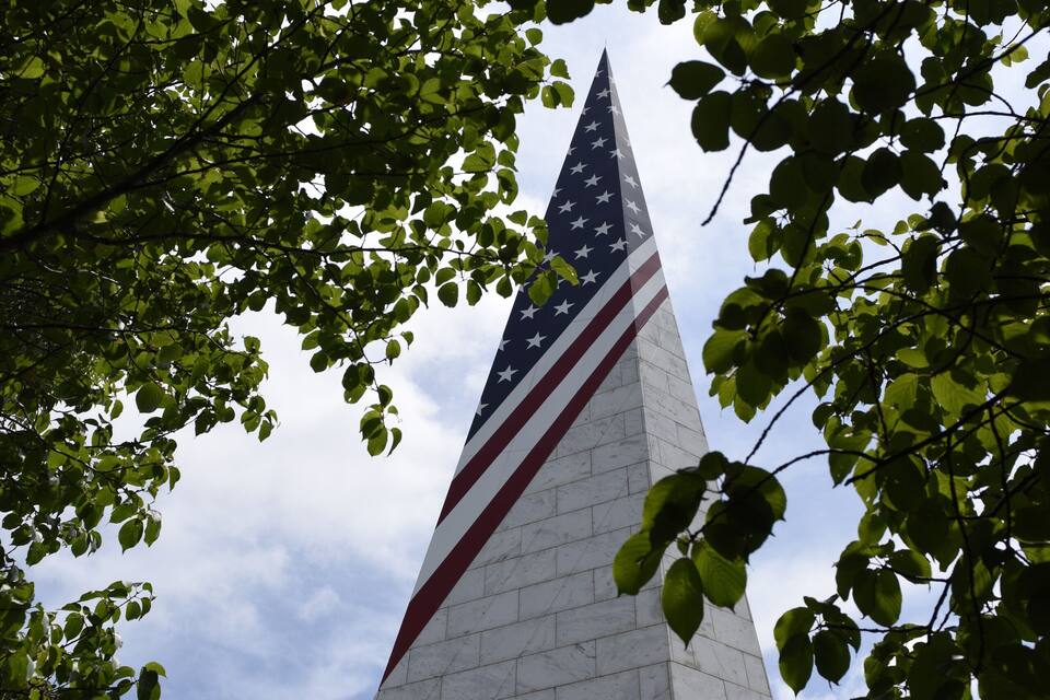 Un grand monument surmonté d’un drapeau américain.