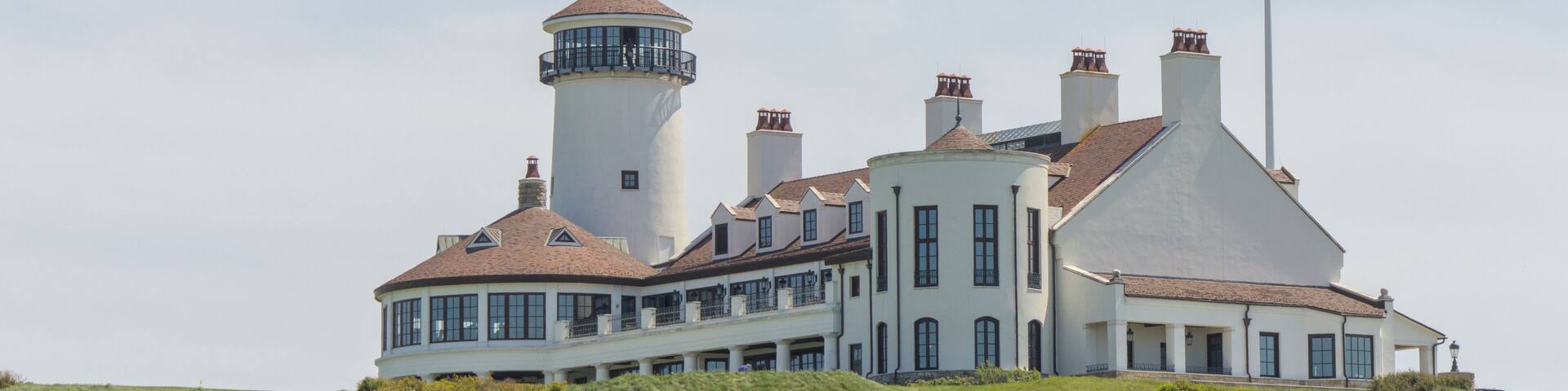 white building on green meadow grass hill next to american flag of the united states of america usa golf course next to hudson river bayonne new jersey
